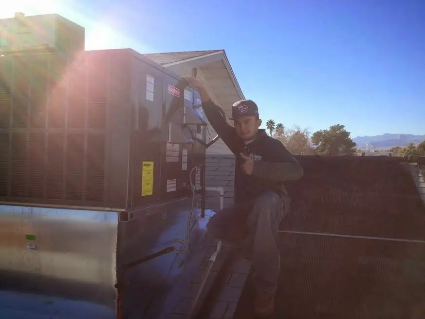 HVAC technician performing AC Tune-Up on a rooftop unit in Eastlake